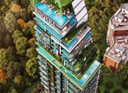 Wohnungsbau in Pattaya mit grünen Terrassen, eingebettet zwischen Bäumen und Bebauung.