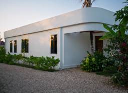 Wohnungsbau in Paje, Region Unguja South, mit Grünflächen um das weiße Gebäude.