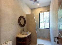 Badezimmer mit Waschbecken, rundem Teppich und Ventilator. Hausbau.