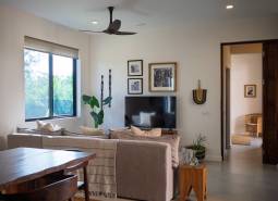 Ein Interieur mit einem Sofa, einem Fernseher und Holzmöbeln im Bau von Häusern.