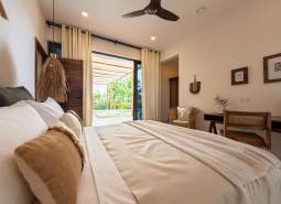 Schlafzimmerinterieur mit geräumigem Bett und Blick auf die Terrasse, Hausbau.