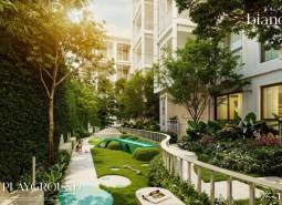 Außenbereich eines Wohnbaus in Phuket mit einem von Grün umgebenen Kinderspielplatz.