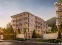 Wohnungsbau in Phuket, ein elegantes Gebäude umgeben von Grün bei Sonnenuntergang.