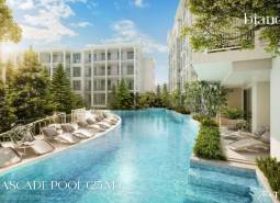 Ein Pool mit Liegestühlen, umgeben von im Bau befindlichen Wohngebäuden in Phuket.