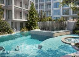 Ein Pool und ein Whirlpool, umgeben von Grünflächen, beim Bau von Wohnungen in Phuket.