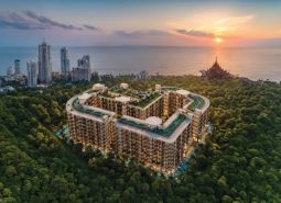Wohnungsbau in Pattaya am Meer, umgeben von Grünflächen und hohen Gebäuden.