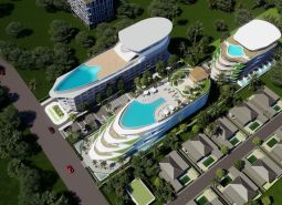 Visualisierung des Wohnungsbaus in Phuket: Mehrstöckige Gebäude mit Pools, umgeben von Grünflächen und einer Straße.