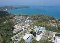 Luftaufnahme des Wohnungsbaus an der Küste von Phuket mit üppigem Grün.