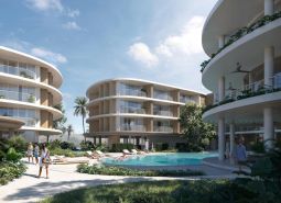 Wohnungsbau in Surat Thani mit abgerundeten Gebäuden und einem Pool in der Mitte des Komplexes.