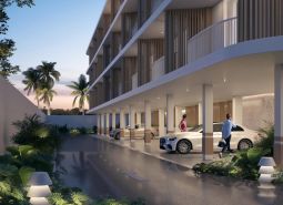 Wohnungsbau in Surat Thani: Parken unter einem modernen Gebäude, umgeben von tropischem Grün.