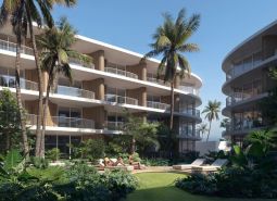Wohnungsbau in Surat Thani: Wohngebäude mit Palmen und Grün im Hintergrund.