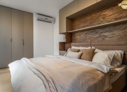 Schlafzimmer mit Doppelbett, Einbauschränken und Boden mit Holzdekor. Wohnungsbau.
