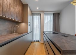 Moderne Küche mit Holzboden und hellen Vorhängen, Wohnungsbau.