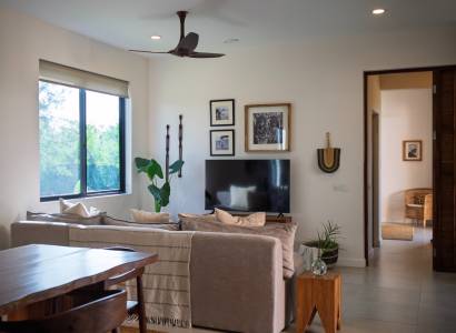 Ein Interieur mit einem Sofa, einem Fernseher und Holzmöbeln im Bau von Häusern.