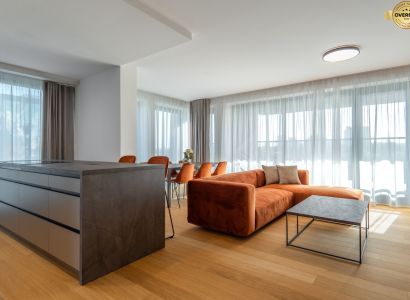 Wohnzimmer mit einem orangefarbenen Sofa, einem Boden in Holzoptik und einem Tisch im Wohnzimmer.