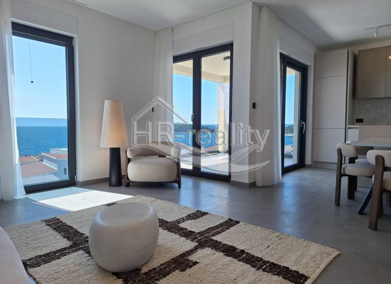 Helles Interieur einer Ferienwohnung mit Meerblick und bequemer Sitzecke.