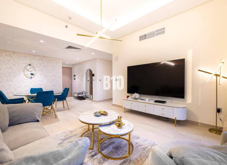 Wohnzimmer in einer 3-Zimmer-Wohnung mit Sofa, Fernseher und Esstisch.