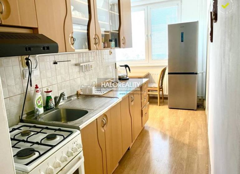 Küche mit Gasherd und Kühlschrank in einer 3-Zimmer-Wohnung, helle Arbeitsplatte.