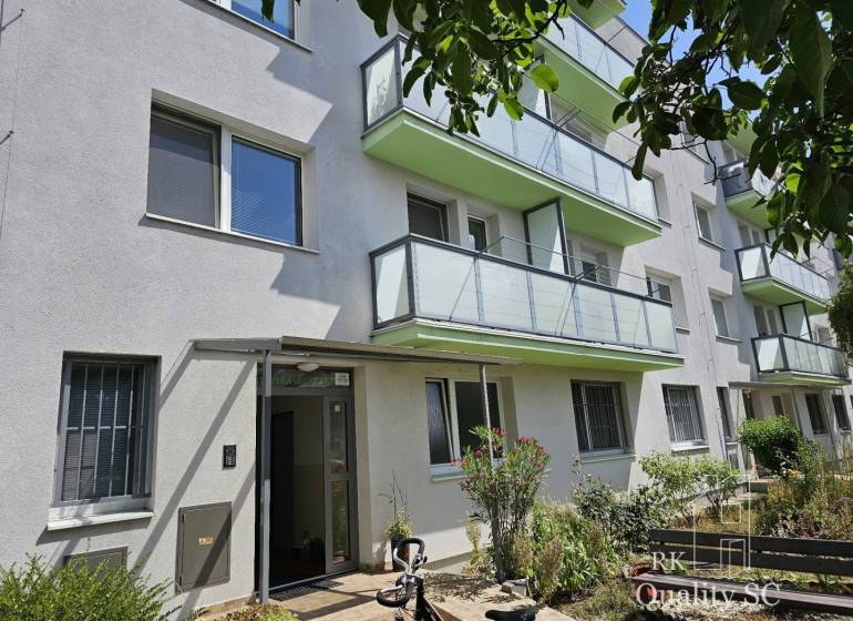Ein Wohncontainer in der Žitavská-Straße in Senec, umgeben von Grün mit verglasten Balkonen.