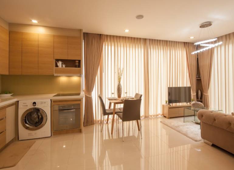 2-Zimmer-Wohnung mit Küche, Wohnzimmer und Essbereich, lichtdurchlässige Vorhänge.