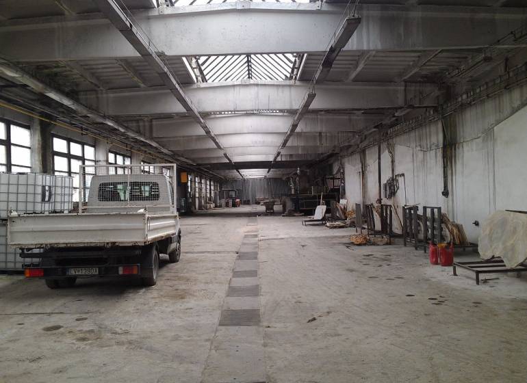 Geräumige Halle mit geparktem Auto und Lagertanks in Levice.