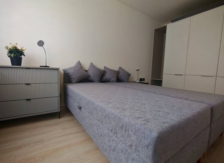 Schlafzimmer mit Bett, Schrank und Kommode in einer Einzimmerwohnung.