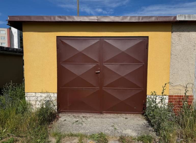 Braune Garage in der Záhradná-Straße in Svit mit Pflanzen rundherum.