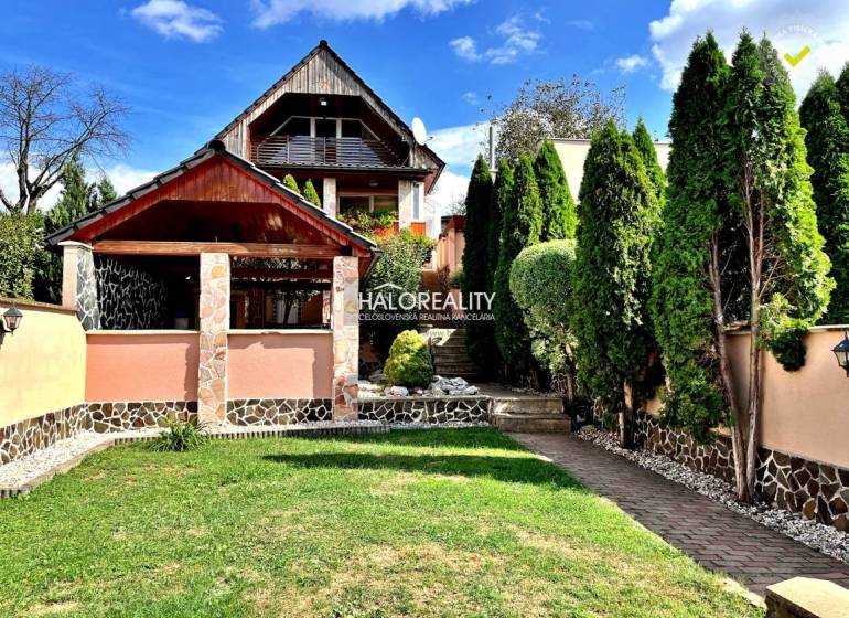 Ein Einfamilienhaus in Levice mit einem gepflegten Garten, einem Pavillon und Bäumen.