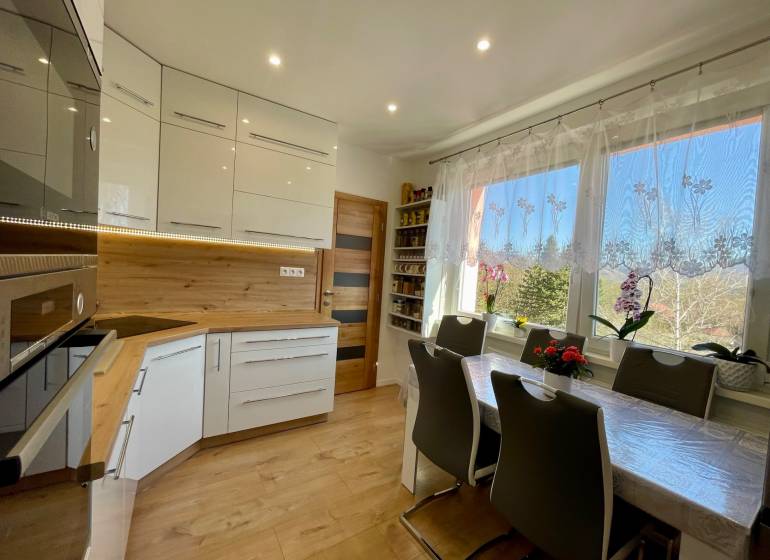 Küche in einer 4-Zimmer-Wohnung mit hellen Möbeln und Esstisch.