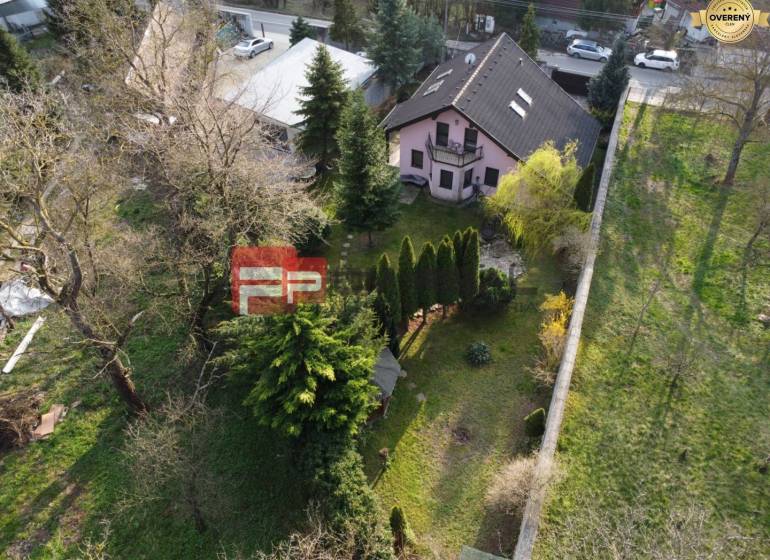 Ein Einfamilienhaus in Píla, umgeben von Bäumen, mit einem gepflegten Garten und benachbarten Gebäuden.