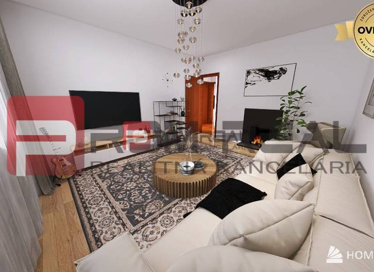 Wohnzimmer in einer 3-Zimmer-Wohnung mit Sofa, Fernseher, Teppich und Gitarre in der Ecke.