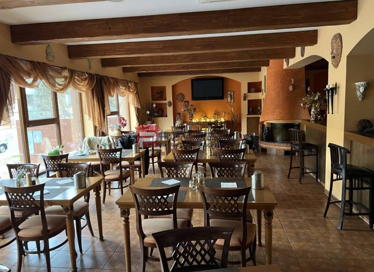 Restaurant mit Holzdecken, Blumendekoration und Kamin, Kategorie Hotels und Pensionen.