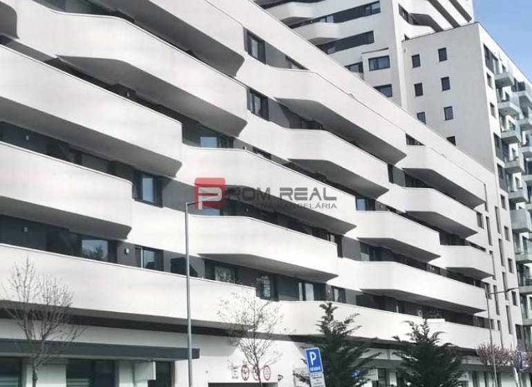 Das Gebäude mit Balkonen in der Údernícka-Straße in Bratislava V, Garagen im Vordergrund.