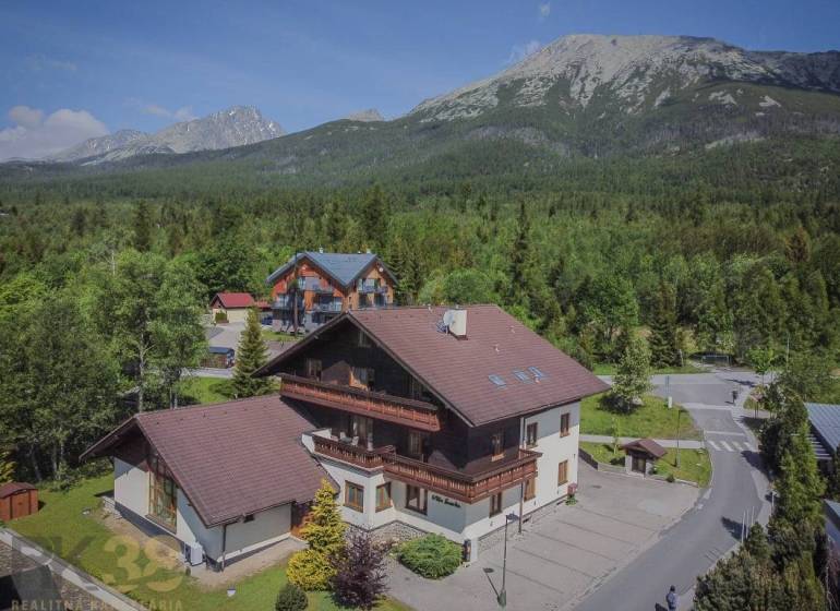 Ferienwohnungen in der Hohen Tatra, umgeben von dichtem Wald und majestätischen Bergen.