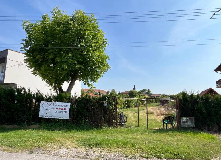 Grundstücke - Wohnen in der Gemeinde Dolný Bar, eingezäuntes Grundstück mit Baum und Tor.
