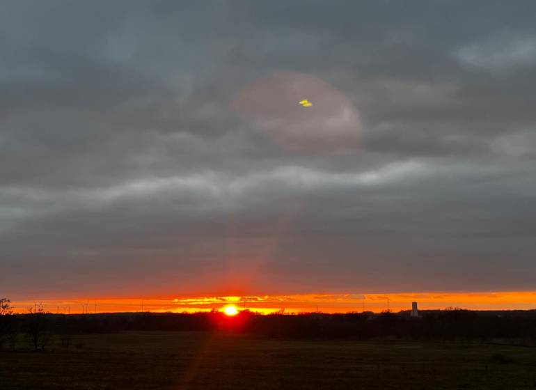 Sonnenuntergang in Bratislava - Devínska Nová Ves mit Windturbinen am Horizont.