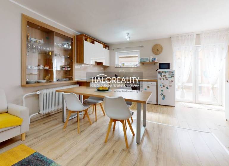 Interieur eines Einfamilienhauses mit Esstisch, Küche und Regalen für Geschirr.