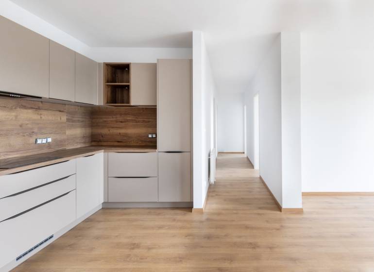 Küche mit Holzelementen und Flur in einer 3-Zimmer-Wohnung, helle und minimalistische Lösung.
