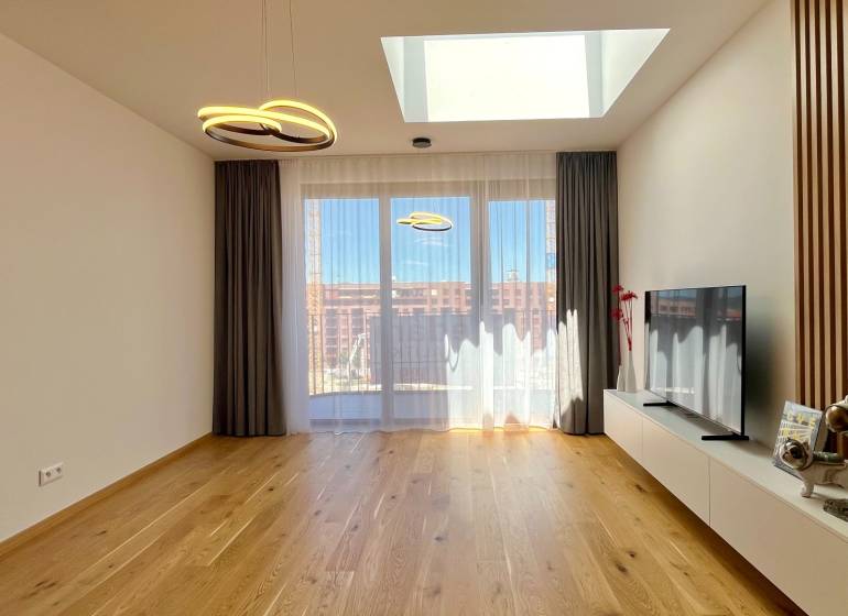 Wohnzimmer in einer Zweizimmerwohnung mit Fernseher und Dekorationen auf dem Boden.