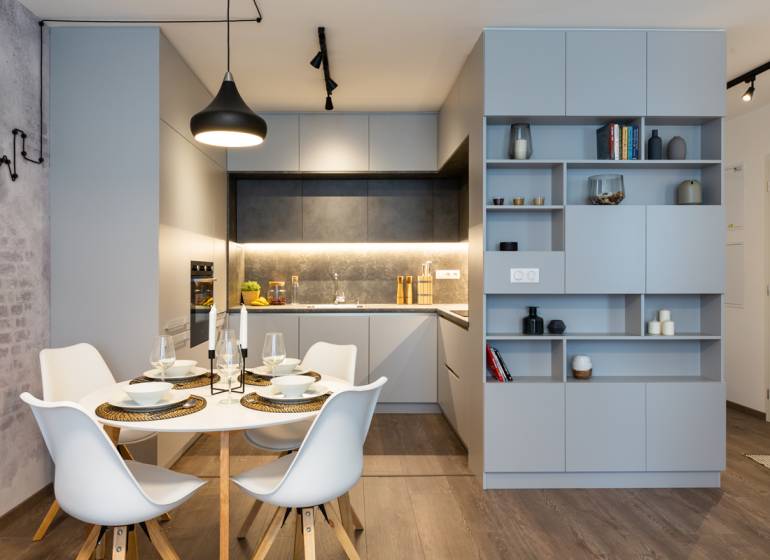 Esszimmer und Küche mit modernen Geräten in einer 2-Zimmer-Wohnung, minimalistisches Design.