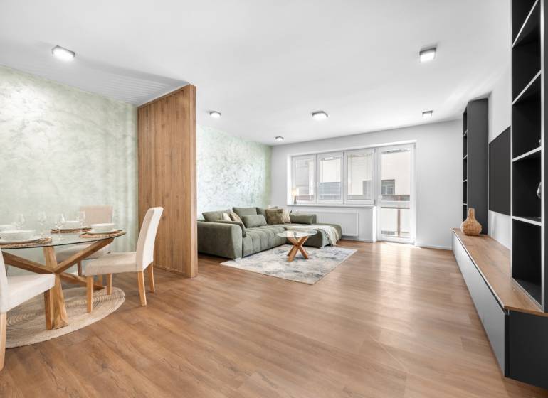 Wohnzimmer in einer 3-Zimmer-Wohnung mit Sofa, Esstisch und modernen Möbeln.