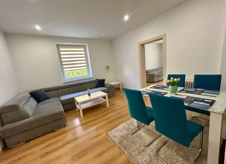 Wohnzimmer in einer 3-Zimmer-Wohnung mit Ecksofa und Esstisch.