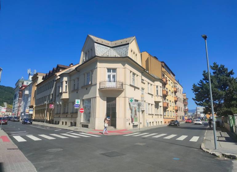 Kreuzung in der Milcova-Straße in Žilina mit Geschäftsräumen und umliegenden Gebäuden.
