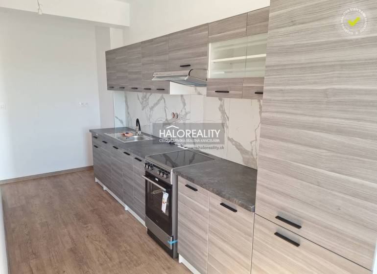 Küche in einer 2-Zimmer-Wohnung mit Holzboden und grauen Schränken.