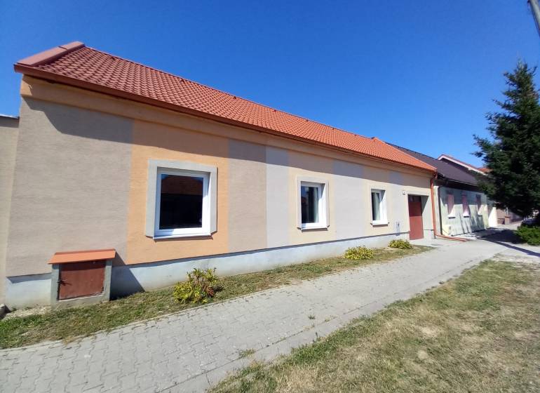Ein Einfamilienhaus in Trakovice mit einer orangefarbenen Fassade und einem roten Dach.