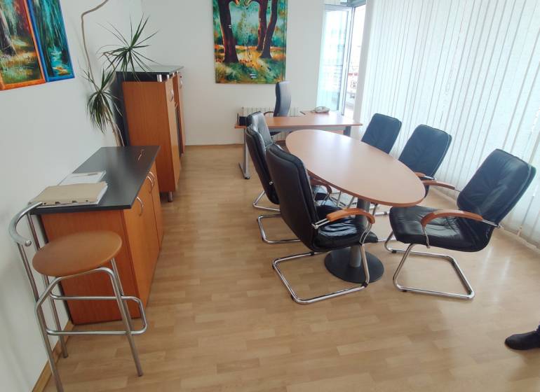 Büros mit rundem Tisch und Stühlen, an der Wand hängt ein Bild.