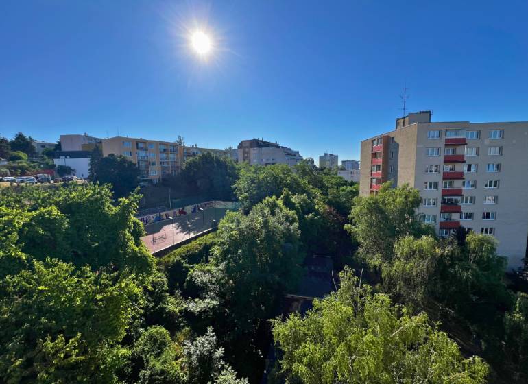 Sonniger Blick auf Grünflächen und Gebäude von einer 2-Zimmer-Wohnung in der Ladzianskeho Straße in Bratislava.