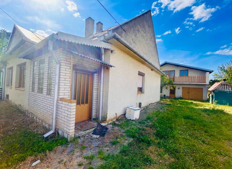 Ein Einfamilienhaus in Sobrance mit einem Rasenstück und einem kleinen Anbau.