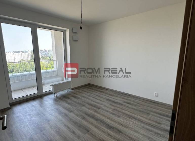 Ein leerer Raum mit Laminatboden und Glastüren in einer Zweizimmerwohnung.