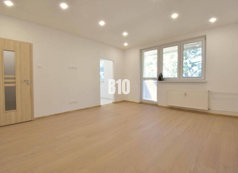 Helles Zimmer in einer 3-Zimmer-Wohnung mit Holzboden und großem Fenster.